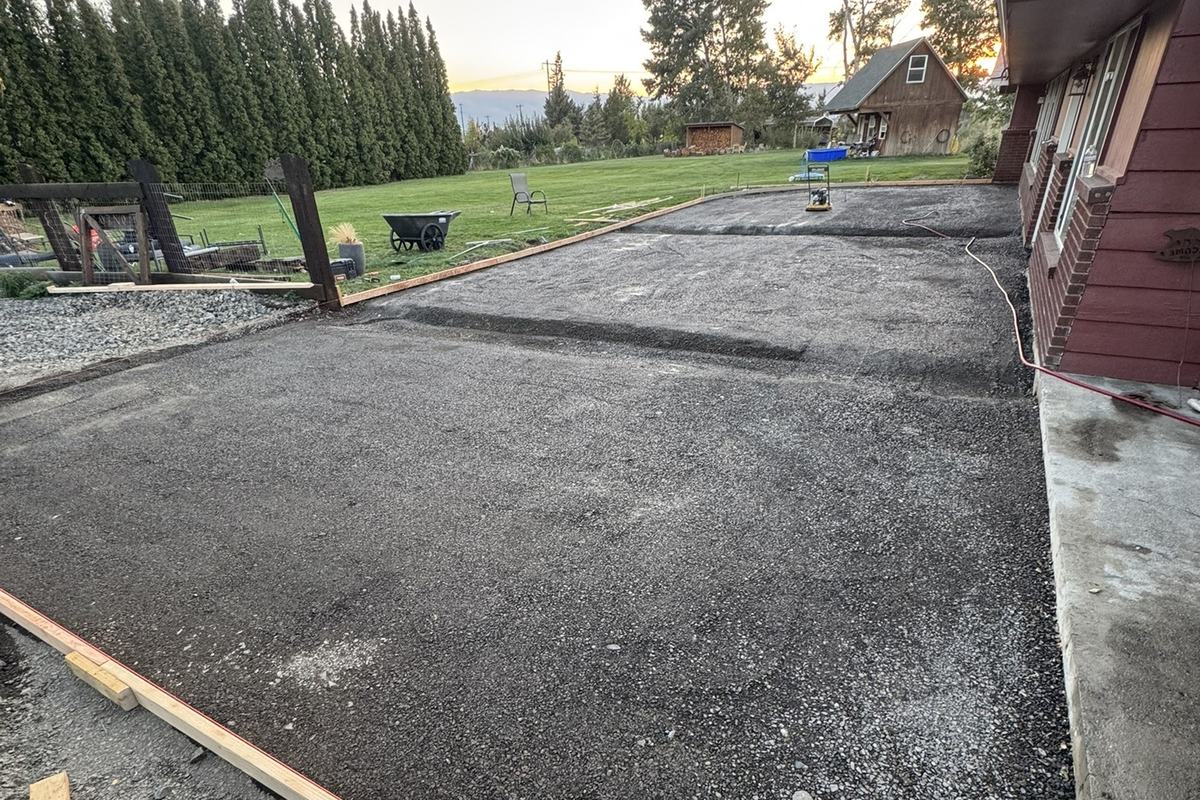Newly paved driveway and apron beside a red barn