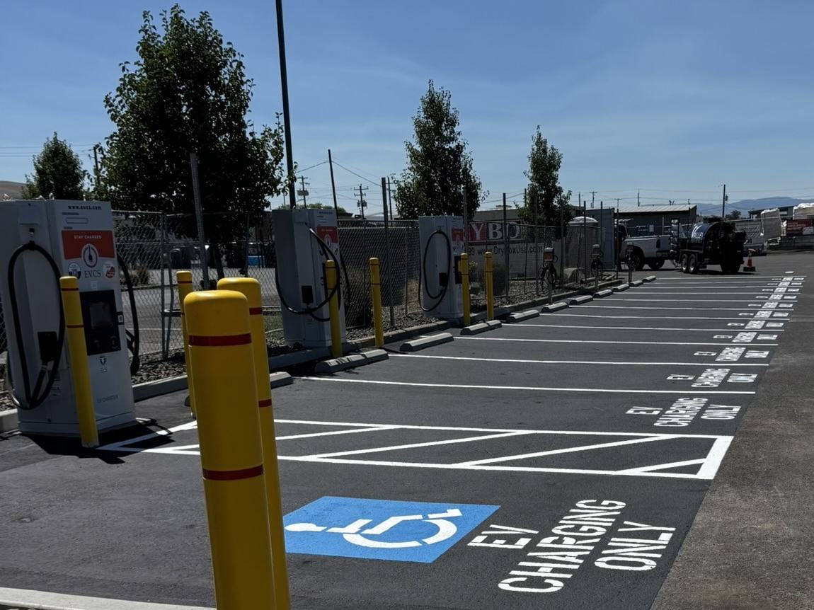 Completed EV charging stall with accessibility striping and bollard protection