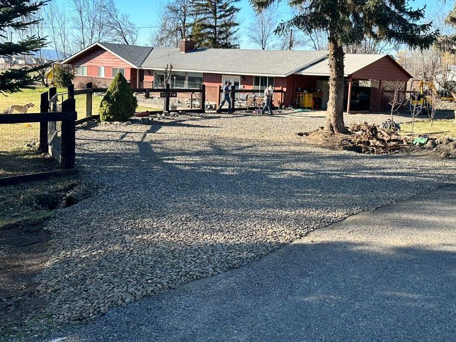 Finished gravel driveway and graded yard at a rural property