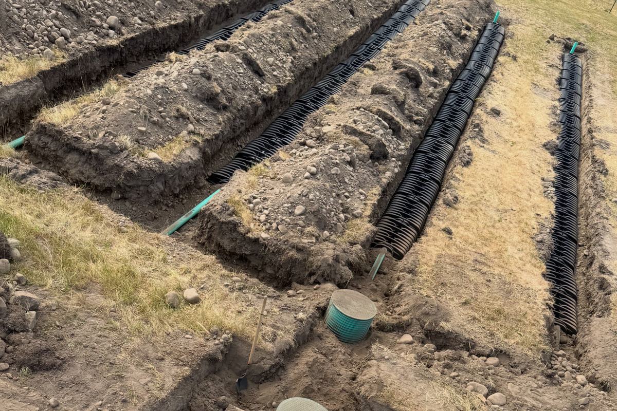 Gravity drainfield trenches with distribution laterals and inspection risers